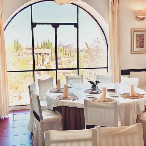 Mesa redonda preparada junto a ventanal arqueado