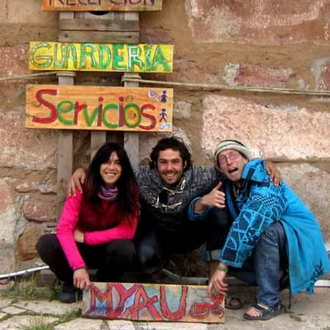 Grupo de personas posando junto a carteles artesanales de servicios comunitarios