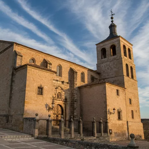 Iglesia de piedra con torre campanario bajo cielo despejado