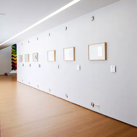 Muro blanco con relieves geométricos en serie.