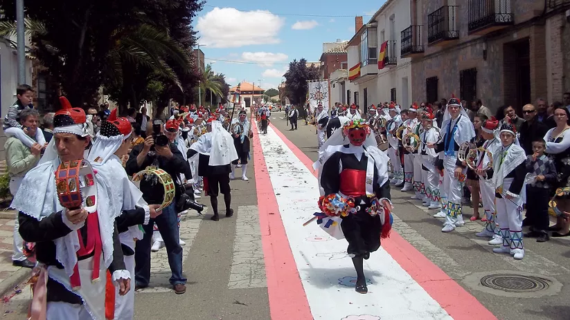Desfile festivo con trajes tradicionales en calle principal