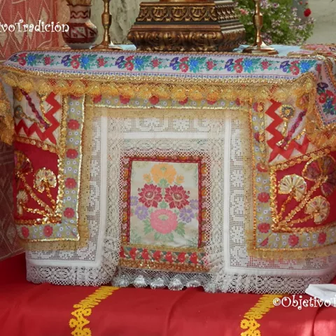 Detalle de mantel bordado y encaje sobre un altar decorado