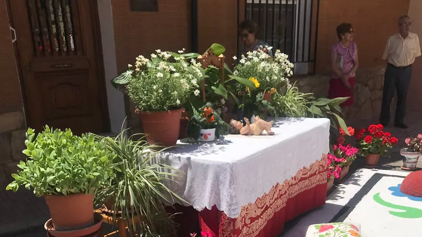 Altar floral decorado en una calle durante una celebración.