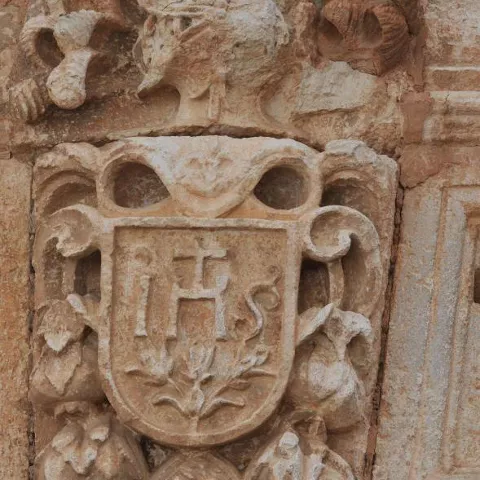 Relieve heráldico tallado en piedra sobre fachada histórica