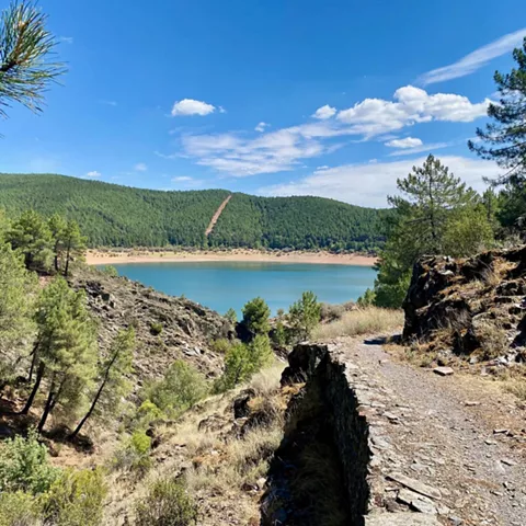 Camino rocoso con lago al fondo.