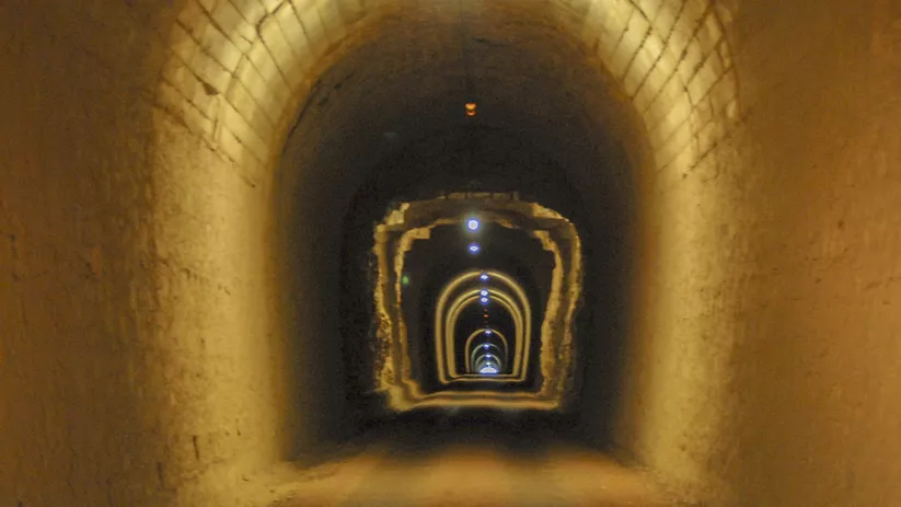 Interior de túnel minero iluminado con perspectiva profunda