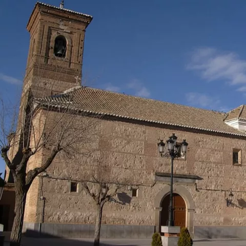 Fachada lateral de iglesia con torre y portada sencilla