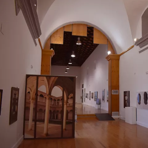 Galería de arte con arcos y paneles expositivos