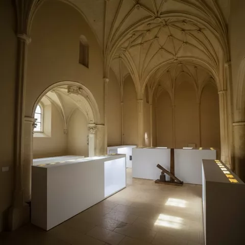 Interior con arcos altos y módulos expositivos iluminados.