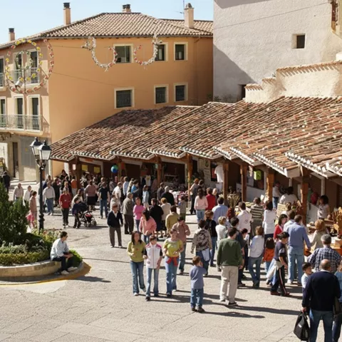 Calle concurrida con mercadillo y puestos bajo soportales.