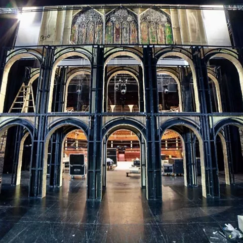 Estructura escénica con arcos y pasarelas montada sobre un escenario.