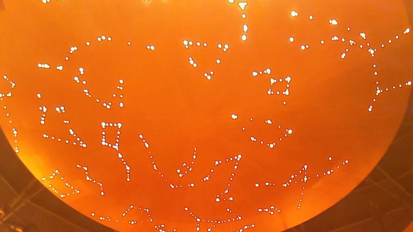 Cúpula interior iluminada con decoración calada y arcos ornamentales.