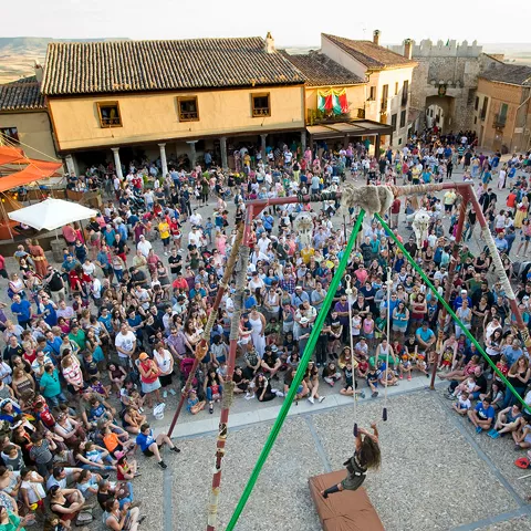 Plaza llena de gente durante fiesta popular al aire libre.