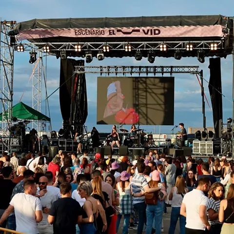 Escenario principal con actuación diurna y público reunido