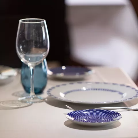 Mesa elegante con vajilla blanca y detalles azules