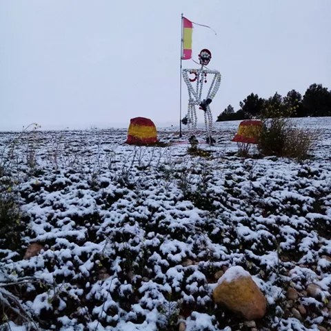 Figura decorativa junto a bandera en paisaje nevado