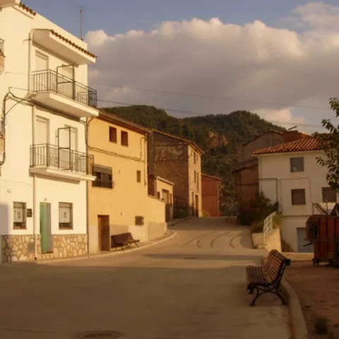 Calle en pendiente con viviendas y bancos