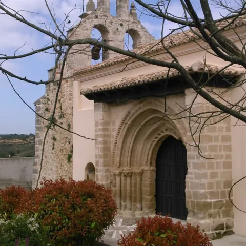 Entrada principal enmarcada por jardín y arbustos.