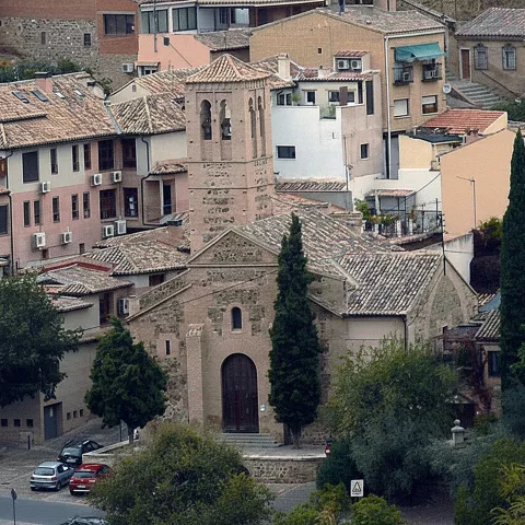 Vista panorámica de iglesia rodeada de viviendas tradicionales.