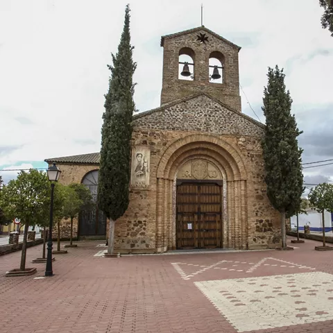 Fachada de iglesia de piedra con espadaña y campanas