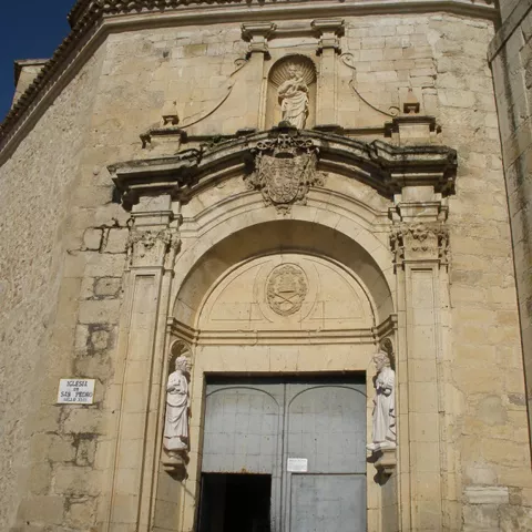 Portada barroca de piedra con esculturas y arco monumental.