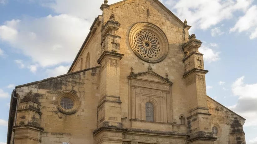 Iglesia de estilo renacentista con gran rosetón y puerta principal abierta.