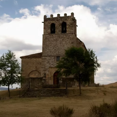 Torre campanario sobre paisaje llano.