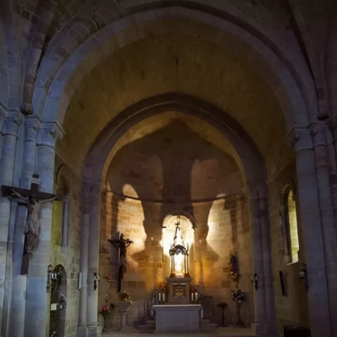 Interior con altar bajo bóveda de piedra.