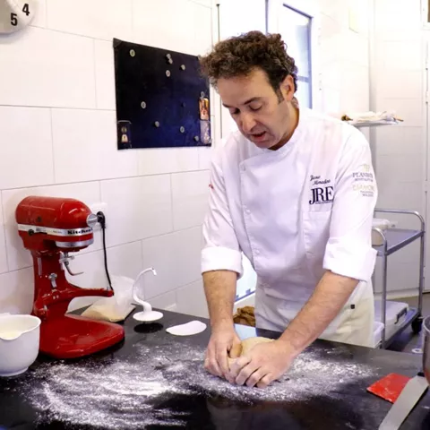 Cocinero amasando sobre una mesa enharinada