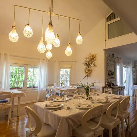 Sala luminosa con mesas vestidas en blanco