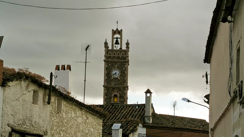 Torre del reloj vista entre tejados y calles estrechas