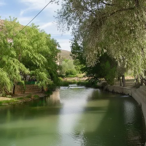 Tramo del río Júcar a su paso por La Recueja, con aguas tranquilas y árboles frondosos en sus orillas.