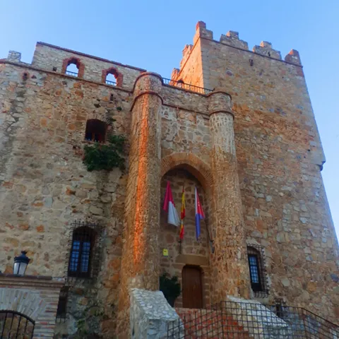 Castillo de piedra con entrada elevada y banderas