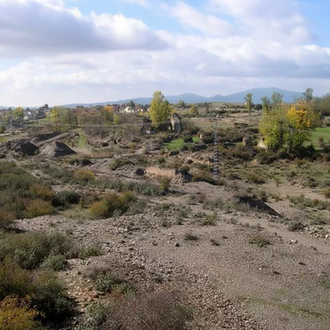 Paisaje minero con escombreras y vegetación.