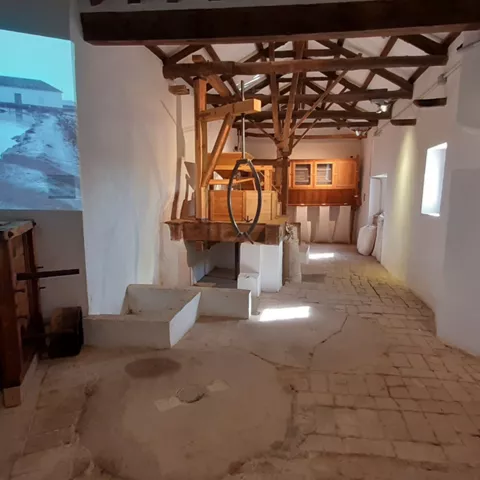 Espacio expositivo con maquinaria hidráulica y estructura de madera