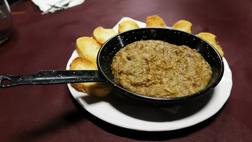 Morteruelo tradicional en sartén con pan tostado
