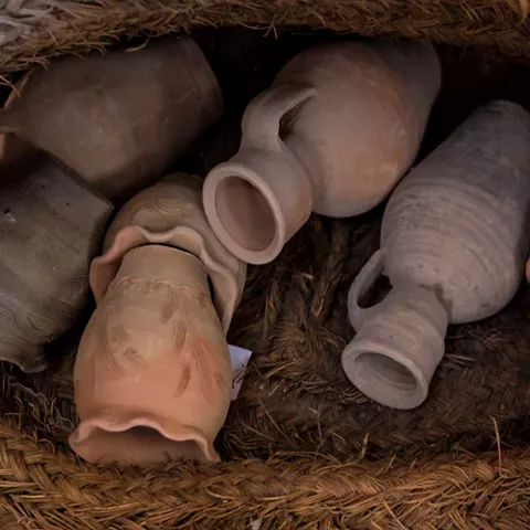 Piezas de cerámica colocadas sobre cesto de esparto en primer plano.