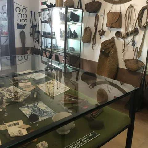 Vitrina con piezas etnográficas y herramientas antiguas expuestas.