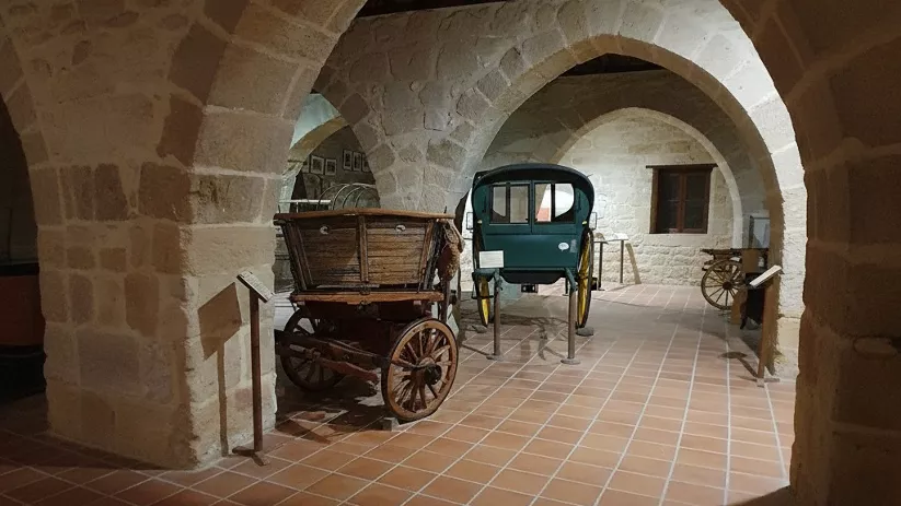 Exposición de carruajes bajo arcos de piedra