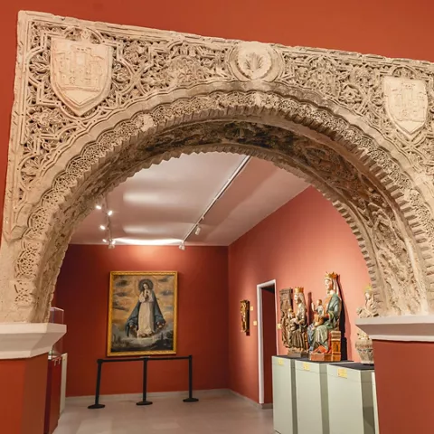 Arco tallado en piedra dentro de espacio expositivo.