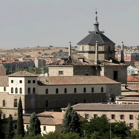 Vista exterior de edificio monumental con cúpula y tejados de teja.