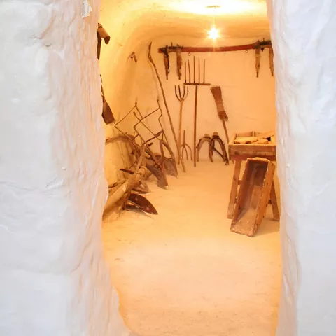 Pasillo blanco con aperos de labranza al fondo