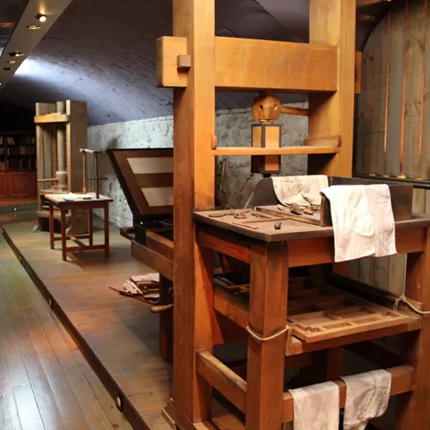 Sala abovedada con antiguas prensas y maquinaria de trabajo artesanal