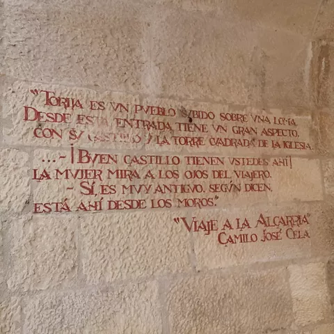 Texto pintado en muro de piedra.