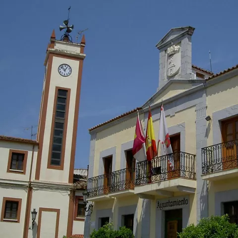 Ayuntamiento con torre estrecha y balcones con banderas