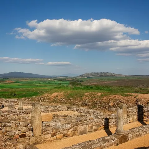 Ruinas arqueológicas con columnas y paisaje de campos al fondo
