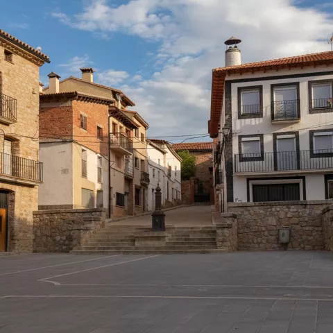 Plaza empedrada con casas tradicionales y escalones centrales.