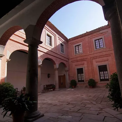 Patio interior porticado con columnas y muros de ladrillo