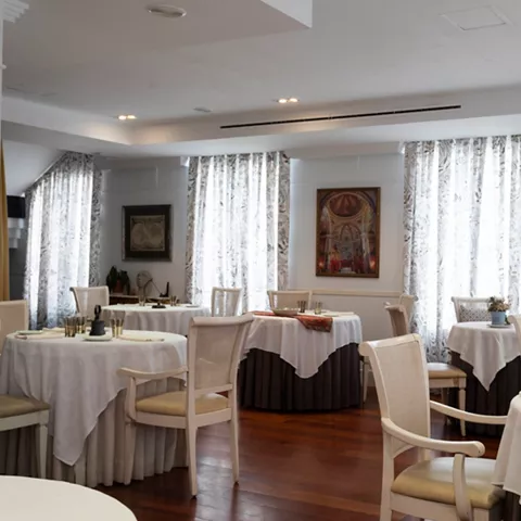 Salón luminoso con mesas vestidas en blanco
