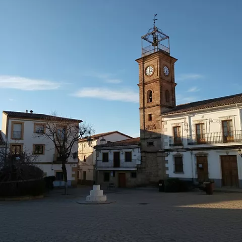 Plaza con torre del reloj y edificios tradicionales
